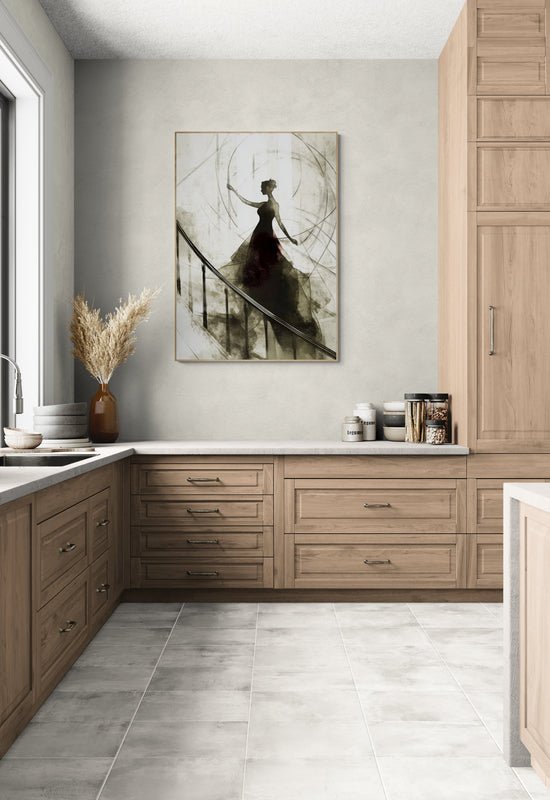Plakat z czarno-białą ilustracją kobiety w balowej sukni na schodach, zawieszony na ścianie w eleganckiej kuchni z drewnianymi szafkami i jasnym blatem