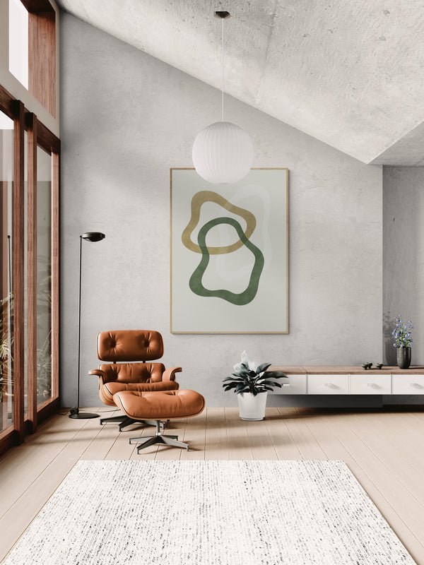 Minimalistyczny plakat z abstrakcyjnymi, organicznymi kształtami w odcieniach zieleni i oliwki, zawieszony w jasnym salonie z dużymi oknami, skórzanym fotelem i białym dywanem.