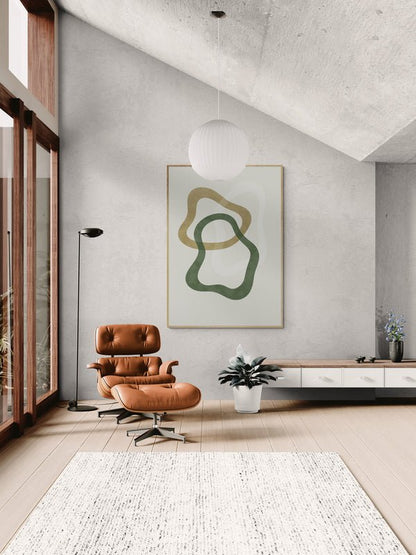 Minimalistyczny plakat z abstrakcyjnymi, organicznymi kształtami w odcieniach zieleni i oliwki, zawieszony w jasnym salonie z dużymi oknami, skórzanym fotelem i białym dywanem.