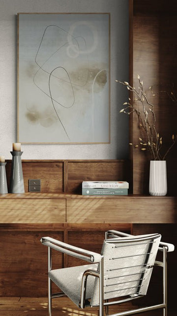 Plakat z jasnym, abstrakcyjnym wzorem zawieszony nad drewnianym biurkiem w stylu retro z metalowym krzesłem i dekoracjami