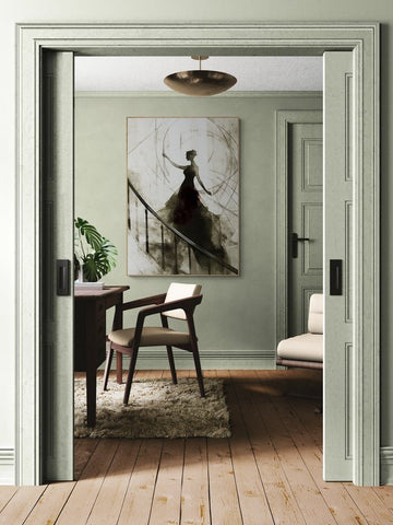 Plakat z ilustracją kobiety w czarnej sukni na schodach, zawieszony na ścianie eleganckiego gabinetu z drewnianą podłogą, biurkiem i klasycznym fotelem