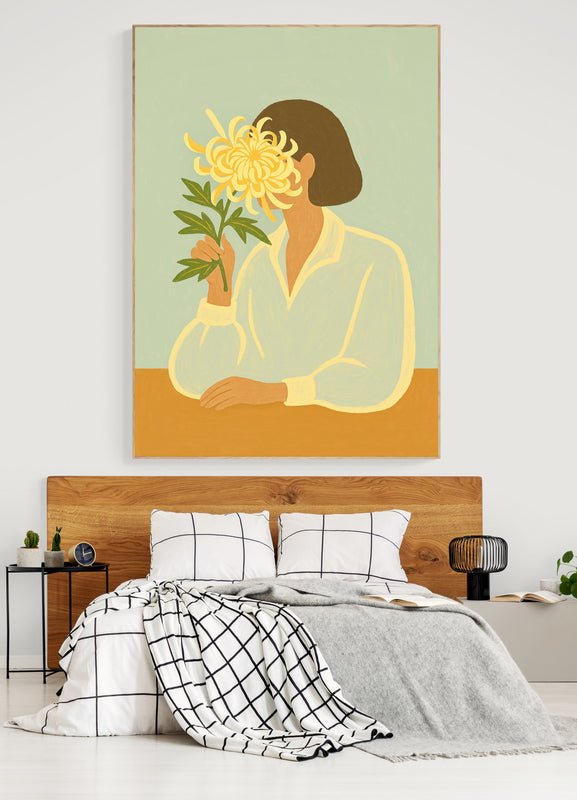 Plakat z ilustracją kobiety trzymającej dużą chryzantemę, zawieszony nad łóżkiem z drewnianym zagłówkiem w nowoczesnej sypialni
